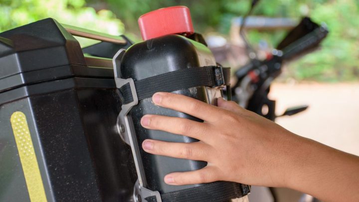Motard préparant les bagages et les équipements de sa moto avant un road trip.